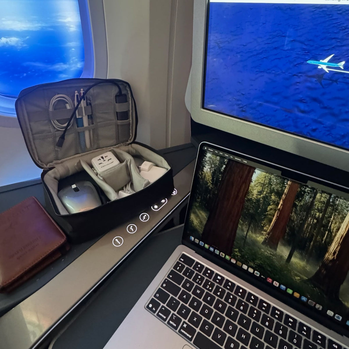 Sharp Travel Tech Organiser Pouch open on a plane tray table with cables and chargers